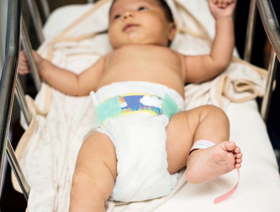 Este niño recién nacido está en la cuna del hospital. Le han puesto un pañal de talla 1.
