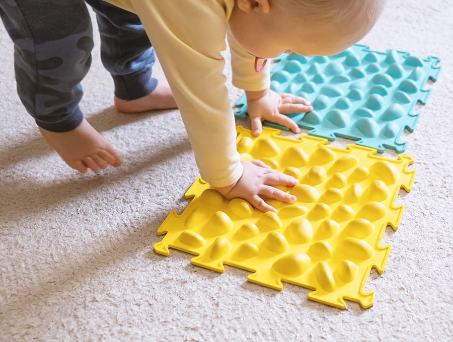 Este bebé está jugando con dos piezas de espuma EVA de la alfombra de juego.