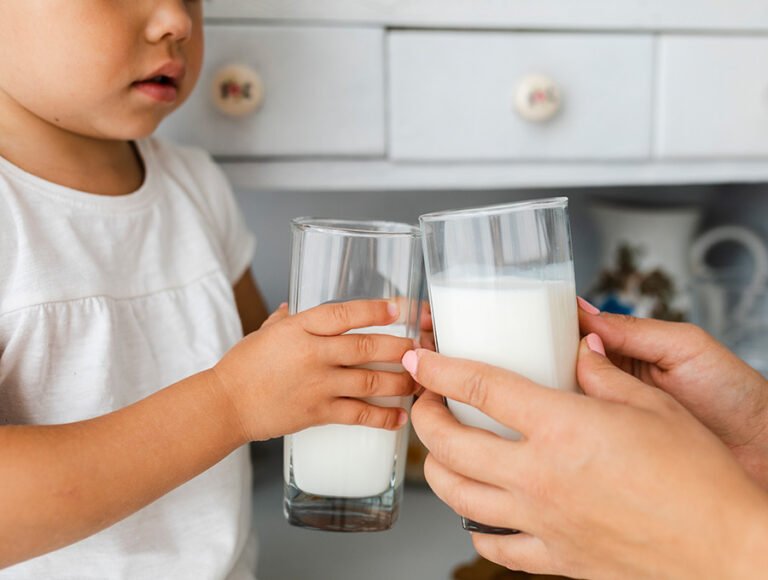 Esta madre se va a tomar un vaso de leche como el de su hijo. Están brindando los vasos para tomarse la leche fría.