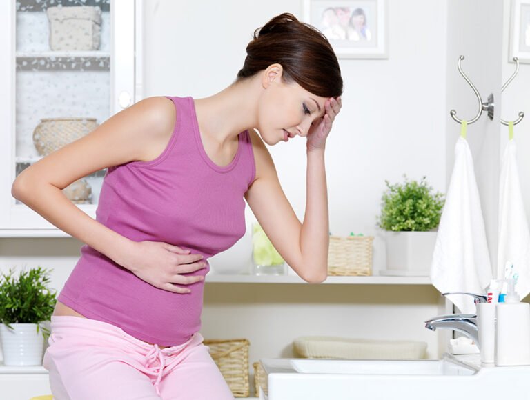 Esta embarazada tiene algo de nauseas. Está en el baño porque no se encuentra bien.