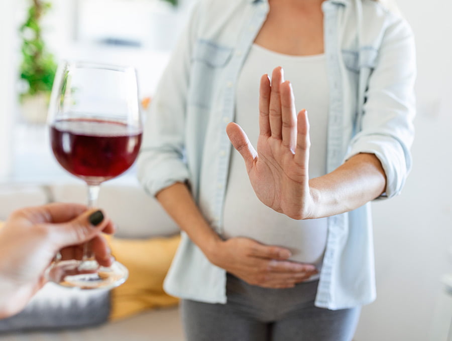 Le ofrecen una copa de vino a una embarazada y ella la rechaza. No se toma alcohol durante el embarazo.
