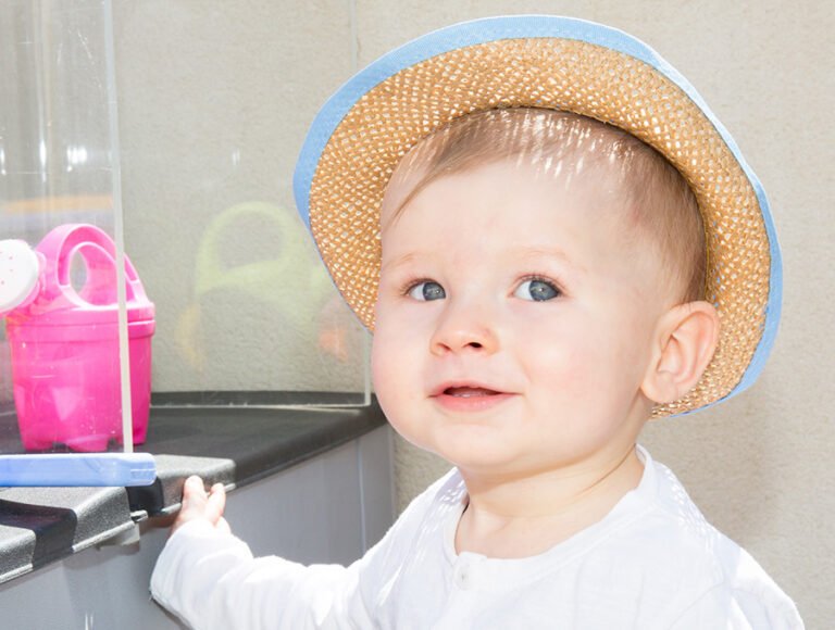 Este niño pequeño lleva un sombrerito de paja para que no le de el sol directo.