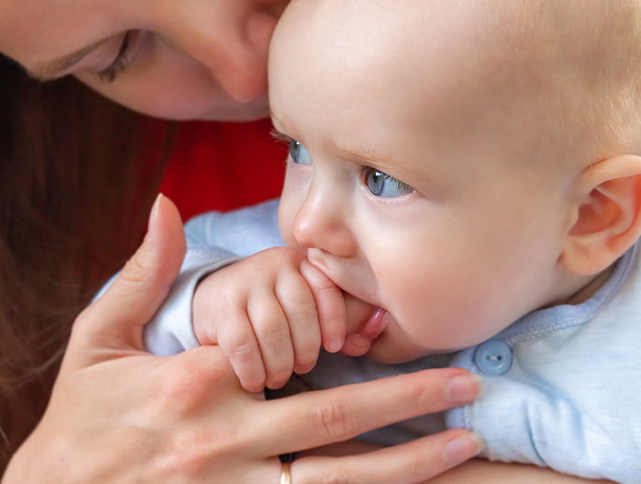 Este bebé está usando el dedo de su madre como si fuera un chupete.
