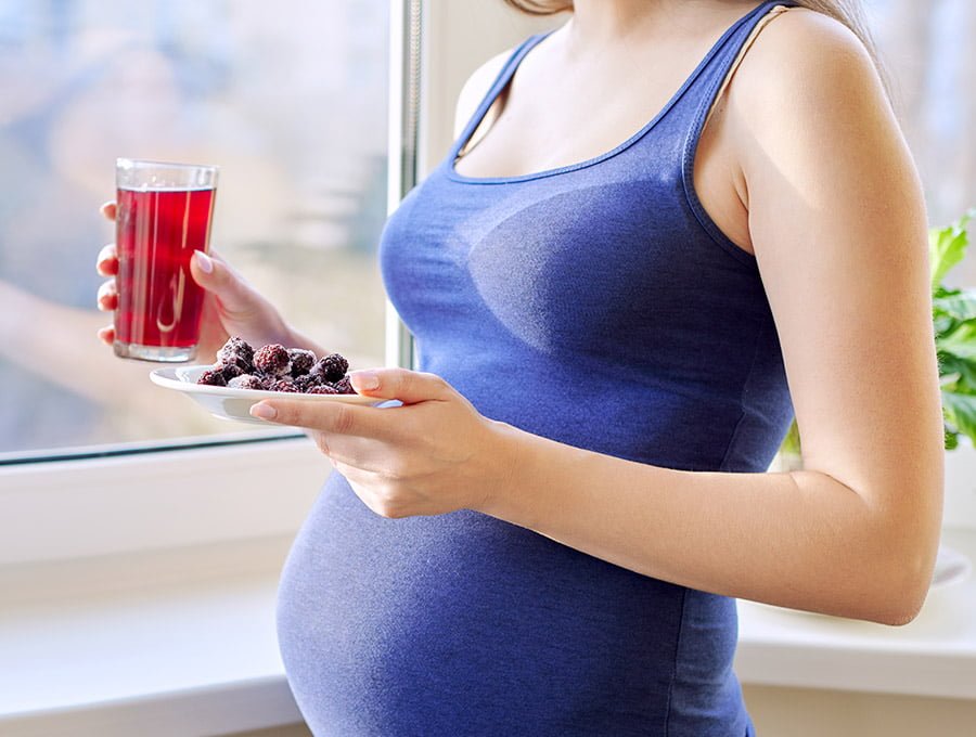 Esta embarazada está tomando un refresco con sabor a fresa.