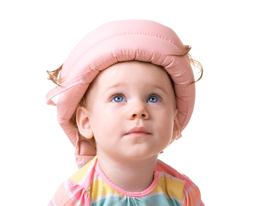 Esta niña pequeña lleva puesto un casco craneal de color rosa.